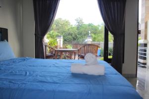 乌鲁瓦图艾迪民宿的一间卧室配有一张蓝色的床,上面有毛巾