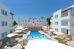 圣埃乌拉利亚卢斯阿科斯公寓式酒店的一座带游泳池和部分白色建筑的度假村
