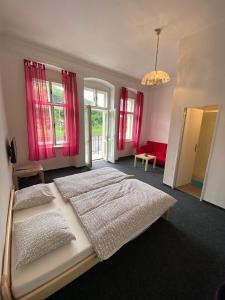 赫任斯科Penzion Hřensko的一间卧室设有两张床和红色窗帘