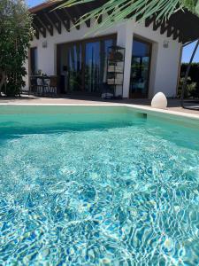 加利波利Villetta Del Salento Exclusive B&B的一座房子前面的蓝色海水游泳池