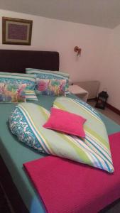 福纽德MG Apartmanház的床上铺有色彩缤纷的床单和枕头