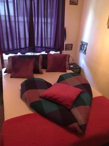 福纽德MG Apartmanház的一间卧室配有两张带红色枕头的床