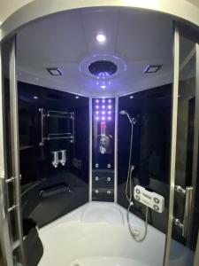 瓦尔斯罗德Villa in Walsrode的带淋浴的浴室(带紫色照明)