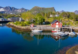 卡伯尔沃格Lofoten sommerhotell og vandrerhjem的码头,有船,红色的房子和山脉