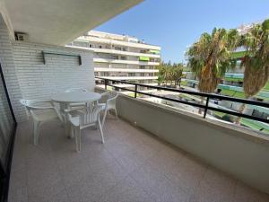 萨洛Apartamento cerca de playa的一个带桌椅的阳台和一座建筑