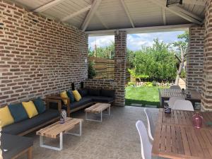 多亚马伊Casa Mediterana的一个带沙发和桌子的庭院和砖墙