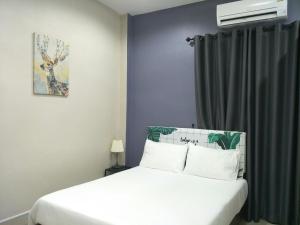 勿洞Betong Cozy Guesthouse เบตง โคซี่ เกสต์เฮาส์的卧室配有白色的床和窗户。
