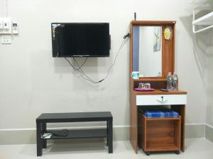勿洞Betong Cozy Guesthouse เบตง โคซี่ เกสต์เฮาส์的配有电视、凳子和镜子的房间