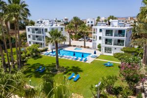 帕福斯罗多达夫妮海滩公寓的享有度假村的空中景致,设有游泳池和棕榈树