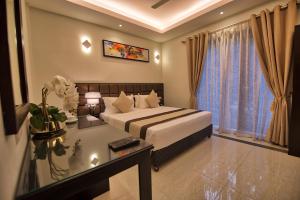 科伦坡Viveka Hotel Colombo的一间卧室配有一张床、一张书桌和一个窗户。