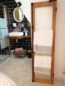 米米藏Chambre d'hôte Margot'te的一间带毛巾架和镜子的浴室