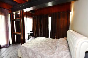 佩斯基耶拉德加达La Terrazza sul Lago的一间设有白色床的卧室,位于带窗户的房间内