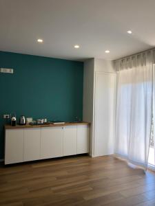 特拉尼SUITE ROOM TRANI的厨房配有白色橱柜和绿色墙壁