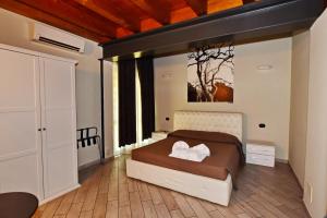 佩斯基耶拉德加达La Terrazza sul Lago的卧室配有一张床,墙上挂有绘画作品
