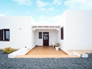 马赫Casa Ocean View的一间白色的房子,设有黑色的门和门廊