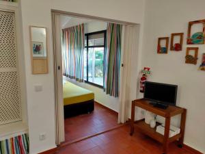 圣卢西亚岛Studio Pedras d'el Rei的客房设有带一张床和电视的卧室。