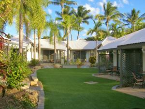 耐莉湾岛屿休闲度假酒店的一座拥有绿色草地和棕榈树的庭院