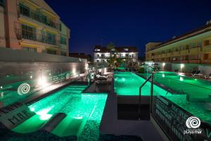 蒙塔尔沃图里斯提考普拉亚马尔艾酒店的夜晚带绿灯的游泳池