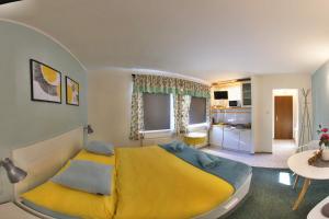 利贝雷茨迷你旅馆的一间带黄色床的卧室和一间厨房