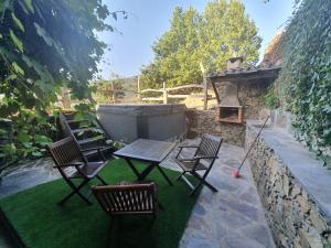 洛萨塔拉斯那尔蒙特哈斯德阿莫尔度假屋的庭院配有桌椅和壁炉
