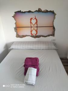 阿尔么丽亚La Burbuja的一张白色的床,上面有粉红色的毛巾