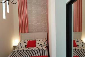 布达佩斯Cozy Design Downtown Apartment的一间卧室配有镜子和一张带红色枕头的床