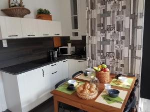 布达佩斯Cozy Design Downtown Apartment的厨房配有一张桌子,上面放着一碗水果