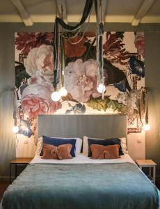 巴古尔Hotel Aiguaclara的一间卧室设有一张带花卉墙壁的大床