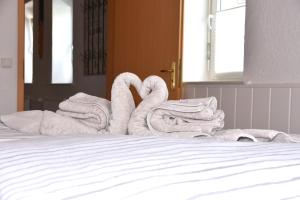代德斯海姆FeWo 1 - Deidesheim的床上的两条毛巾天鹅