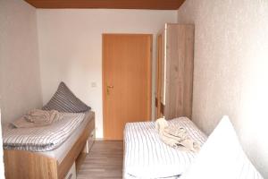 代德斯海姆FeWo 1 - Deidesheim的小房间设有两张床和一个衣柜
