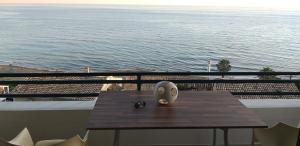 格利法达Glyfada Home 113 by New Era in Menigos Resort Apartments的海景阳台上的桌子