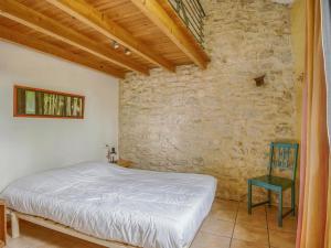 Ponet-et-Saint-AubanCosy holiday home with garden的一间卧室设有一张床和石墙