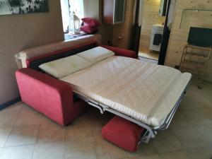 BalmeAppartamento Curnet的一张位于一个红色沙发的房间的床铺和一张四柱床