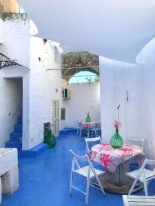 卡斯特里尼亚诺德尔卡波ChicchiSanti的客房铺有蓝色的地板,配有桌椅。
