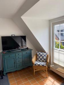 韦斯特兰Kastanienhüs Apartment的客厅配有蓝色橱柜和电视
