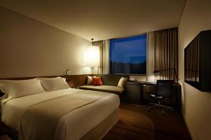 华城市新罗东滩住宿酒店的酒店客房配有一张床、一张桌子和一把椅子。