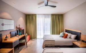 马格达拉Magdala Hotel的配有一张床和一张书桌的酒店客房