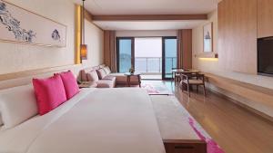 象山宁波象山海景皇冠假日酒店的酒店客房配有一张带粉红色枕头的大型白色床。