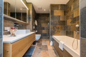 萨斯格伦德Montela Hotel & Resort - Apartments的带浴缸、卫生间和盥洗盆的浴室
