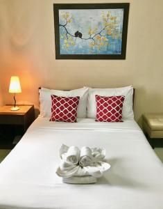 马尼拉莱斯登西亚精品公寓式酒店的卧室配有带红色枕头的白色床