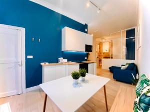 蒙彼利埃Suite Bayle - Standing - Hyper centre的客厅配有白色桌子和蓝色的墙壁