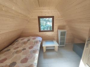 雅罗斯瓦维茨Agroturystyka i Domki Zacisze的小木屋内的卧室,配有床和窗户