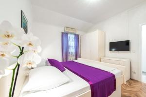 扎通Villa Mare & Filip的卧室配有白色床和紫色床单