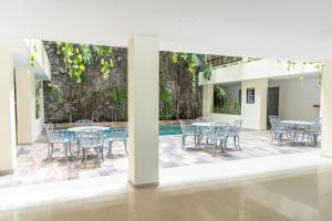 韦拉克鲁斯Grand Hotel KYRIOS Veracruz的一个带桌椅的庭院和一个游泳池
