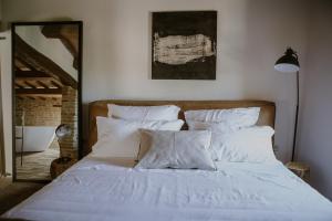 LoretelloBorgo Loretello的卧室内的一张带白色床单和枕头的床