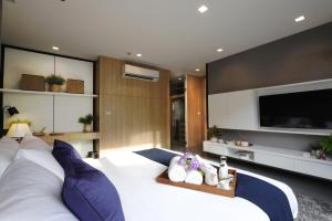 曼谷Alix Bangkok Hotel的卧室配有一张白色大床和一台平面电视。