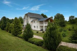 ČatrnjaStudio apartments Kaya的一座白色的大房子,有树木的院子