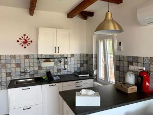 福纽德Exclusive Beachfront Villa的厨房配有白色橱柜和黑色台面