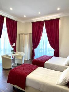 切里尼奥拉Villa Pallotta Luxury B&B的酒店客房,设有两张床、书桌和窗帘
