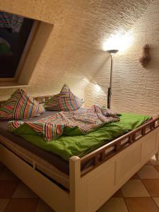 巴特施瓦尔陶Salzoasen Apartment的一张带绿色棉被和枕头的床